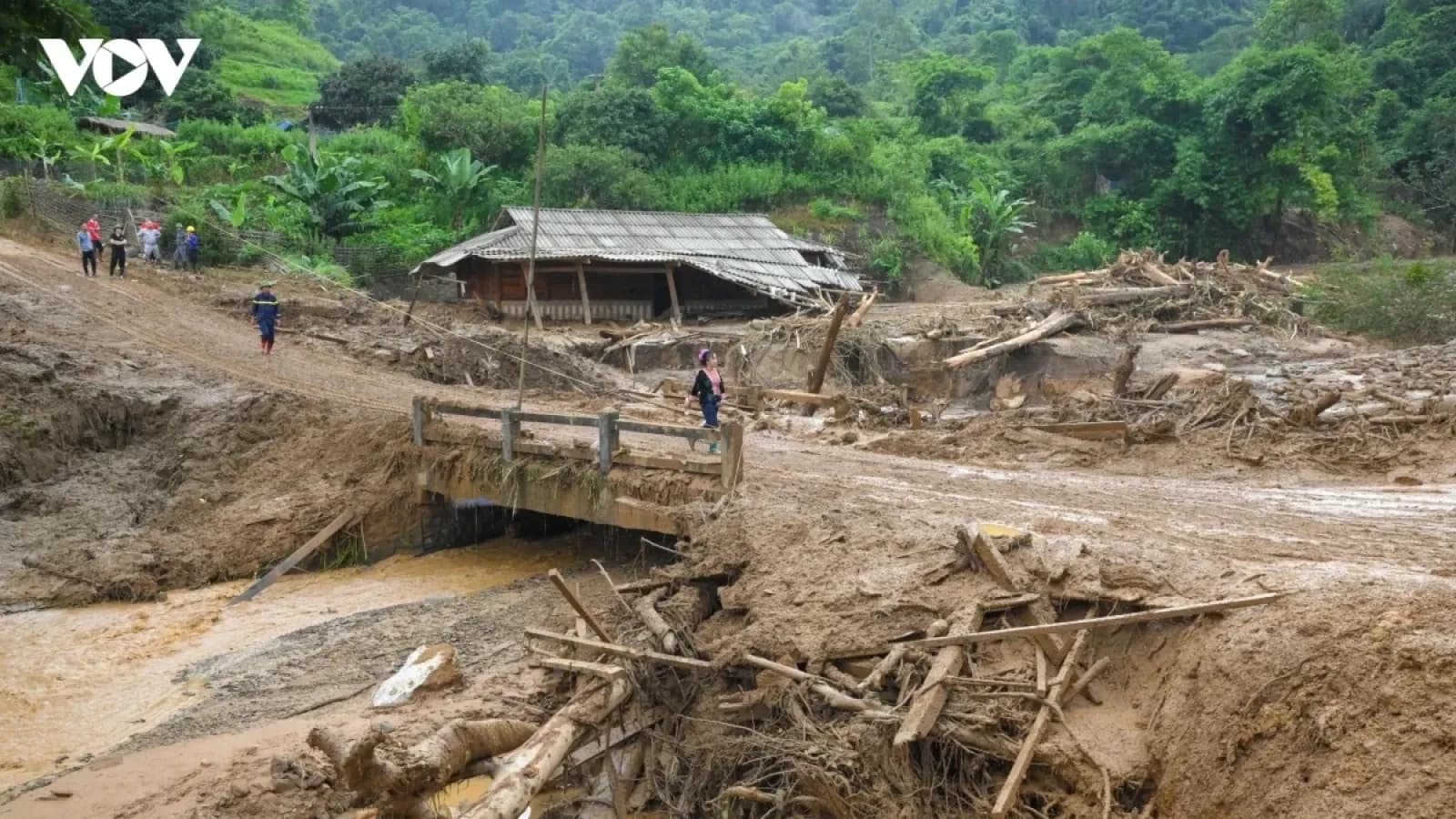Khu vực nông thôn bị tàn phá nặng nề bởi lũ lụt và sạt lở đất, người dân đứng nhìn khung cảnh hoang tàn, nhấn mạnh nhu cầu đầu tư vào khả năng phục hồi.