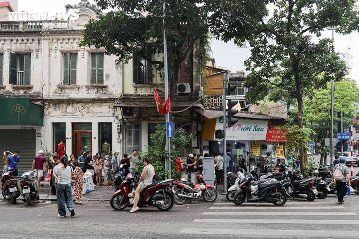 Khung cảnh nhộn nhịp tại một khu chợ truyền thống ở Hà Nội vào dịp Tết Hàn thực, với nhiều người mua bán bánh trôi, bánh chay.