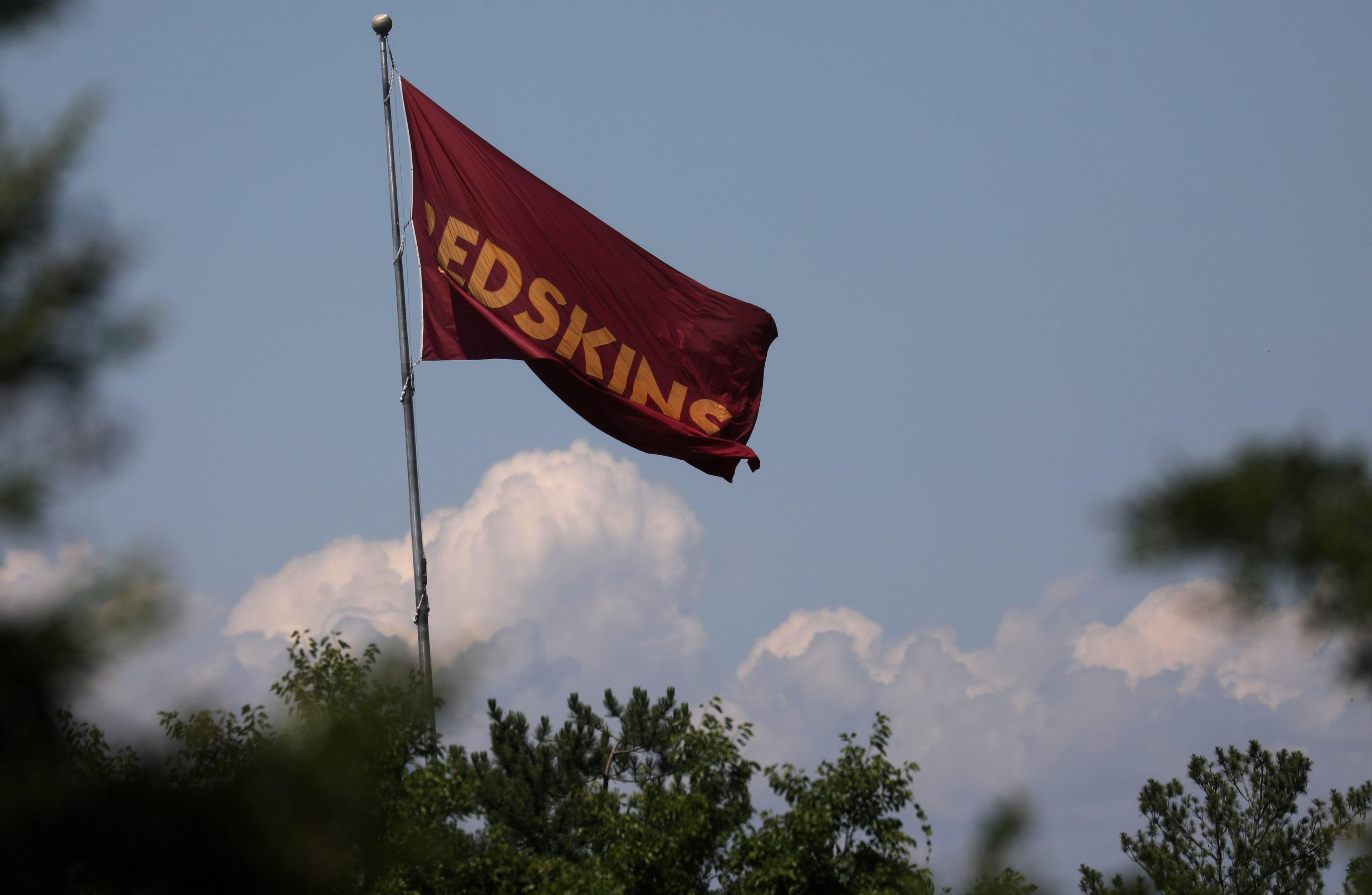Lá cờ mang thương hiệu Redskins bay trên bầu trời, tượng trưng cho lịch sử và sự thay đổi bản sắc của đội bóng NFL Washington Commanders.