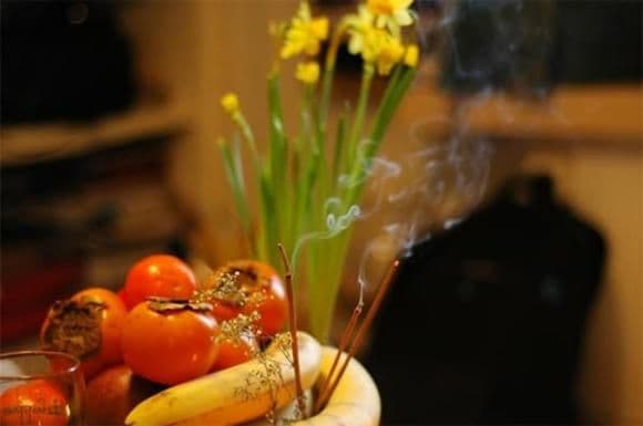 Lễ vật dâng cúng gồm trái cây tươi và nén hương đang cháy, tượng trưng cho lòng thành kính trong nghi lễ.