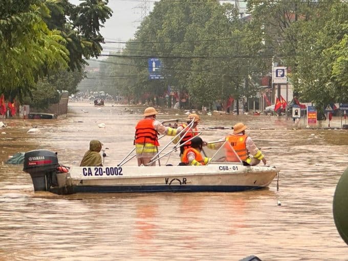 Lực lượng chức năng dùng thuyền cứu hộ di chuyển trên đường phố ngập lụt ở Thái Nguyên, thực hiện công tác cứu nạn.