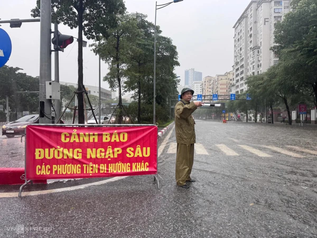 Lực lượng chức năng hạn chế phương tiện đi vào đường Võ Chí Công do ngập sâu, thể hiện công tác ứng phó và cảnh báo nguy hiểm trong bối cảnh thời tiết khắc nghiệt ở miền Bắc.