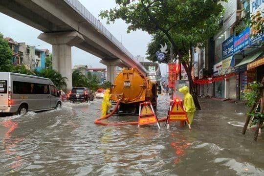 Lực lượng chức năng xử lý ngập lụt trên đường phố Hà Nội, thể hiện sự thay đổi và thích nghi của giao thông đô thị.