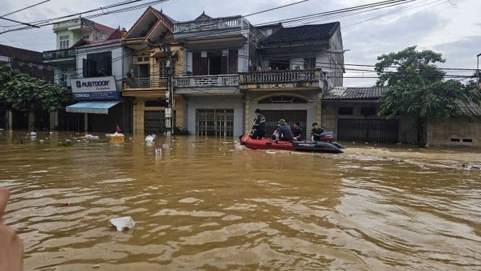 Lực lượng cứu hộ di chuyển bằng xuồng trên đường phố ngập lụt ở vùng hạ du Lạng Sơn
