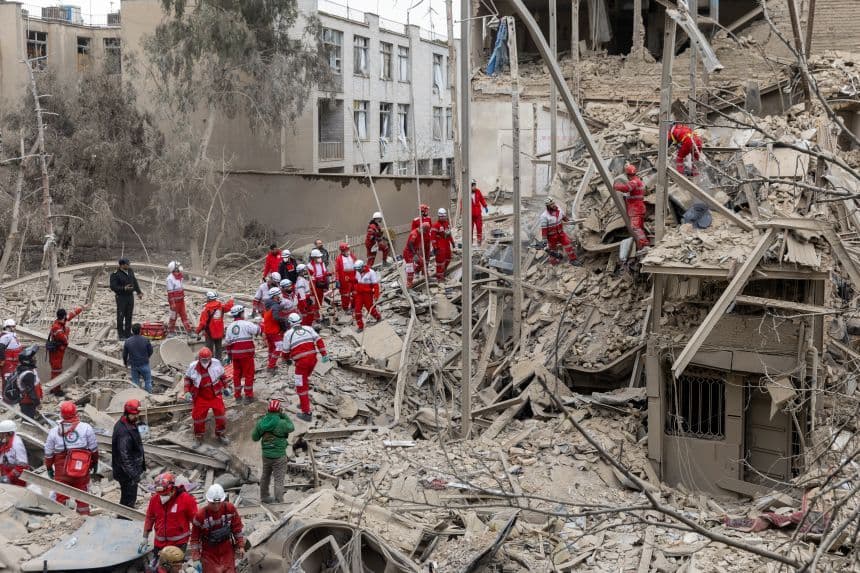 Lực lượng cứu hộ tìm kiếm người sống sót trong đống đổ nát của một tòa nhà dân cư ở Tehran sau một cuộc tấn công, minh họa cho sự leo thang căng thẳng ở Iran.