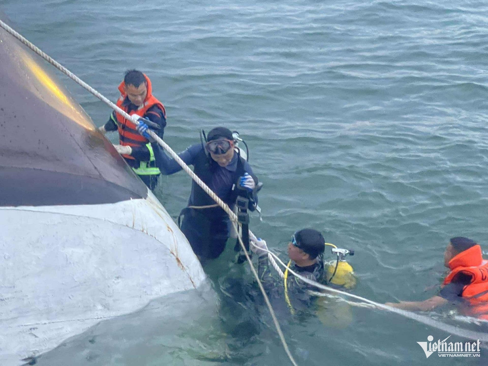 Lực lượng cứu hộ và thợ lặn đang tìm kiếm nạn nhân quanh con tàu bị lật trên vịnh Hạ Long.