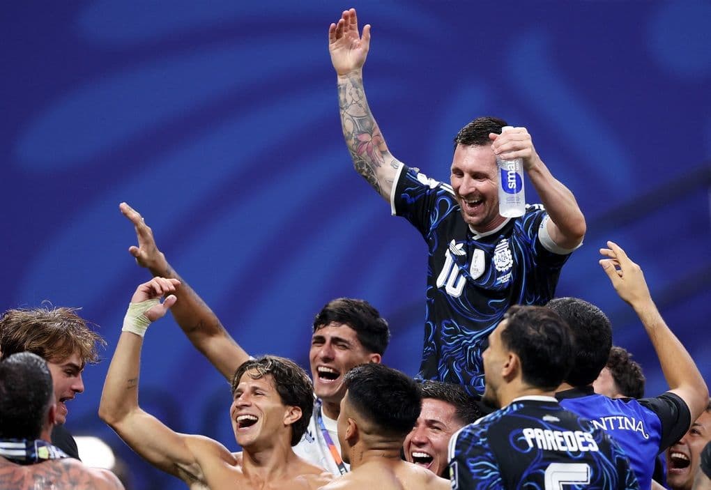 Lionel Messi ăn mừng chiến thắng cùng đồng đội sau trận chung kết World Cup, thể hiện niềm vui và áp lực được giải tỏa.