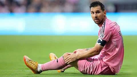 Lionel Messi ngồi trên sân cỏ với vẻ mặt suy tư, phản ánh những lo ngại về chất lượng và bản sắc của World Cup trong tương lai.