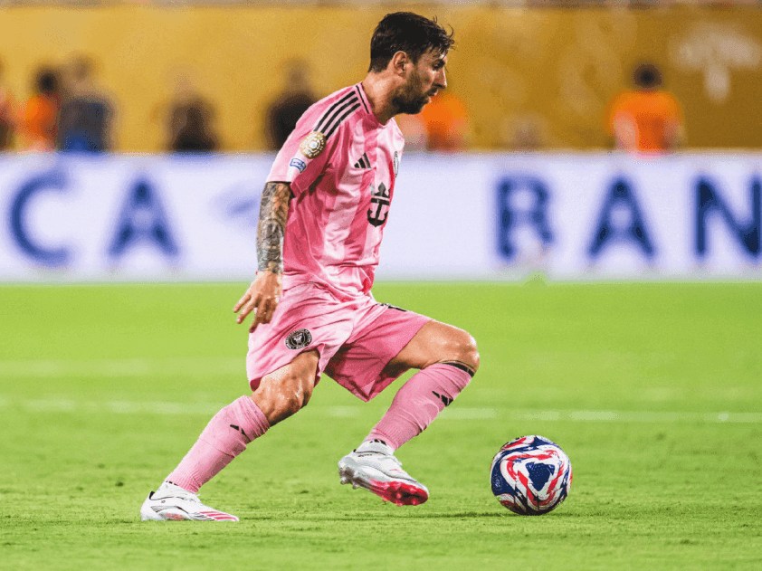 Lionel Messi trong màu áo Inter Miami đang dẫn bóng trên sân cỏ.
