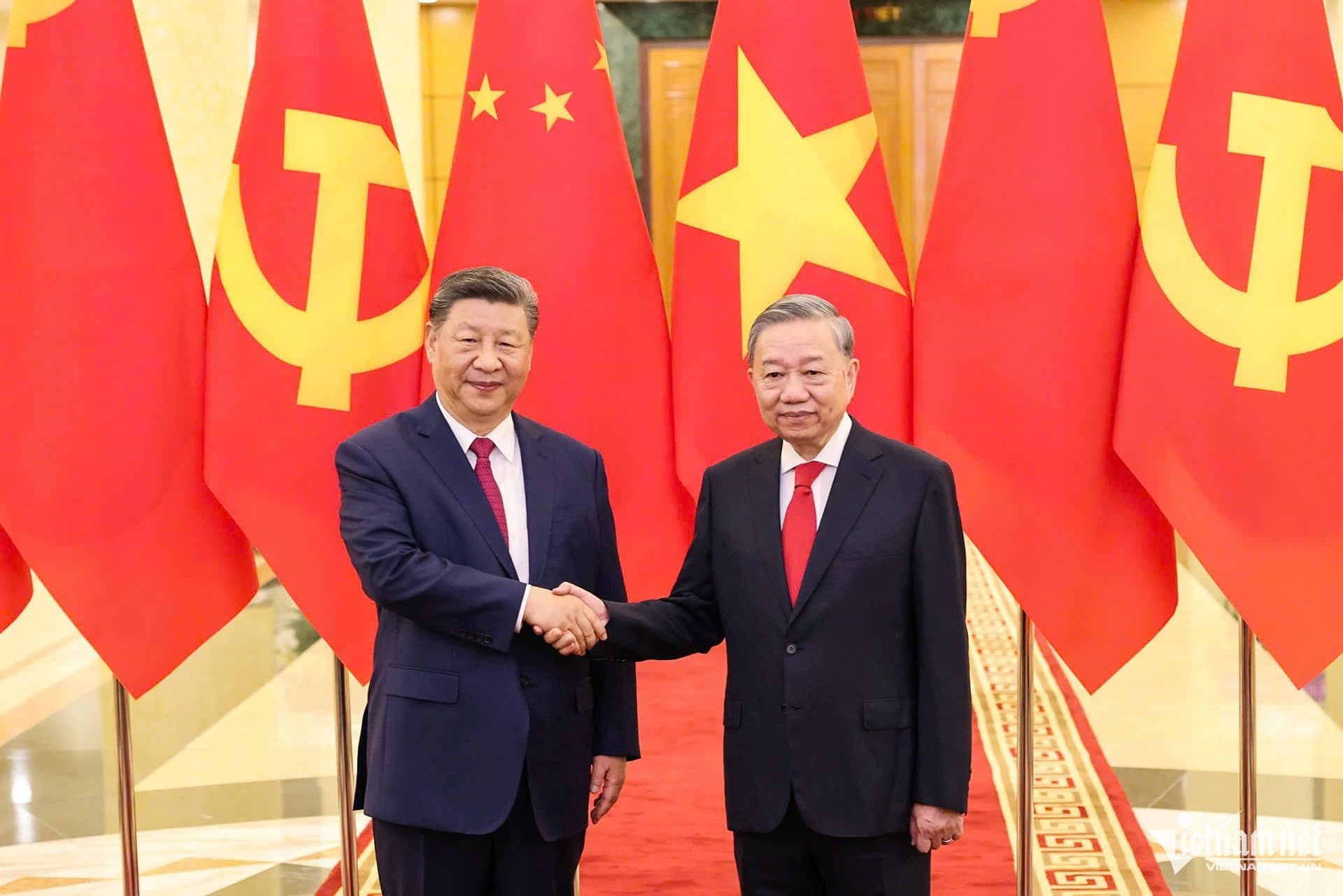 Lãnh đạo cấp cao Việt Nam và Trung Quốc bắt tay trước quốc kỳ hai nước, biểu tượng của tình hữu nghị "vừa là đồng chí vừa là anh em".