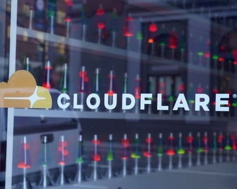 Logo Cloudflare trên cửa sổ trụ sở, biểu tượng của công ty hạ tầng internet