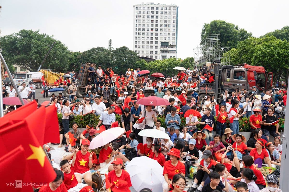 Đám đông người dân Hà Nội mặc áo cờ đỏ sao vàng, cầm cờ Việt Nam, tập trung chờ xem diễu binh 2/9.