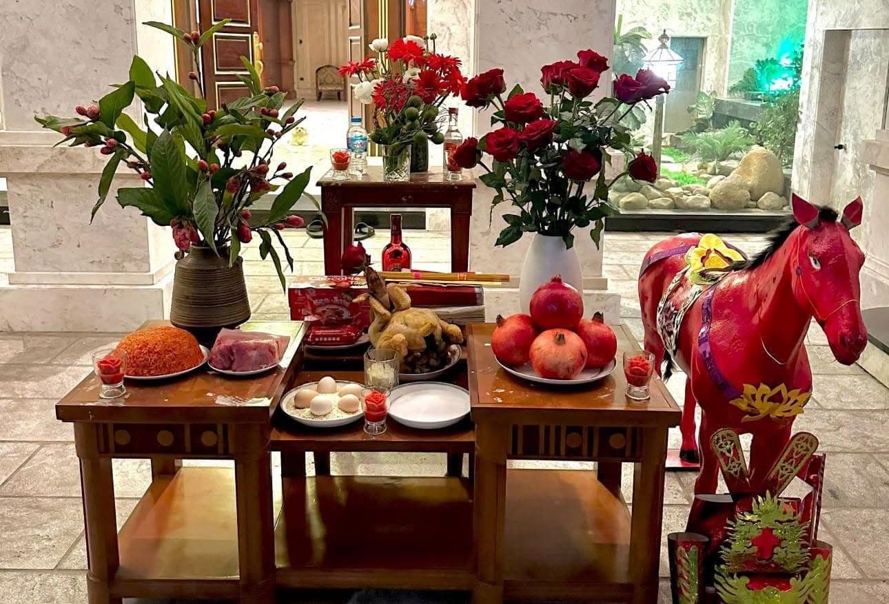 Mâm cỗ cúng giao thừa ngoài trời với các lễ vật truyền thống và hình nộm ngựa đỏ, chuẩn bị đón thần linh năm mới