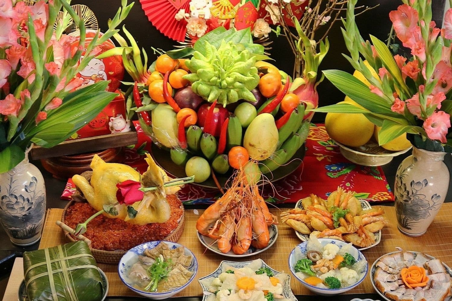 Mâm cỗ cúng mùng 1 truyền thống đầy đủ với gà luộc, xôi, nem, trái cây và hoa tươi, thể hiện bản sắc văn hóa Việt.