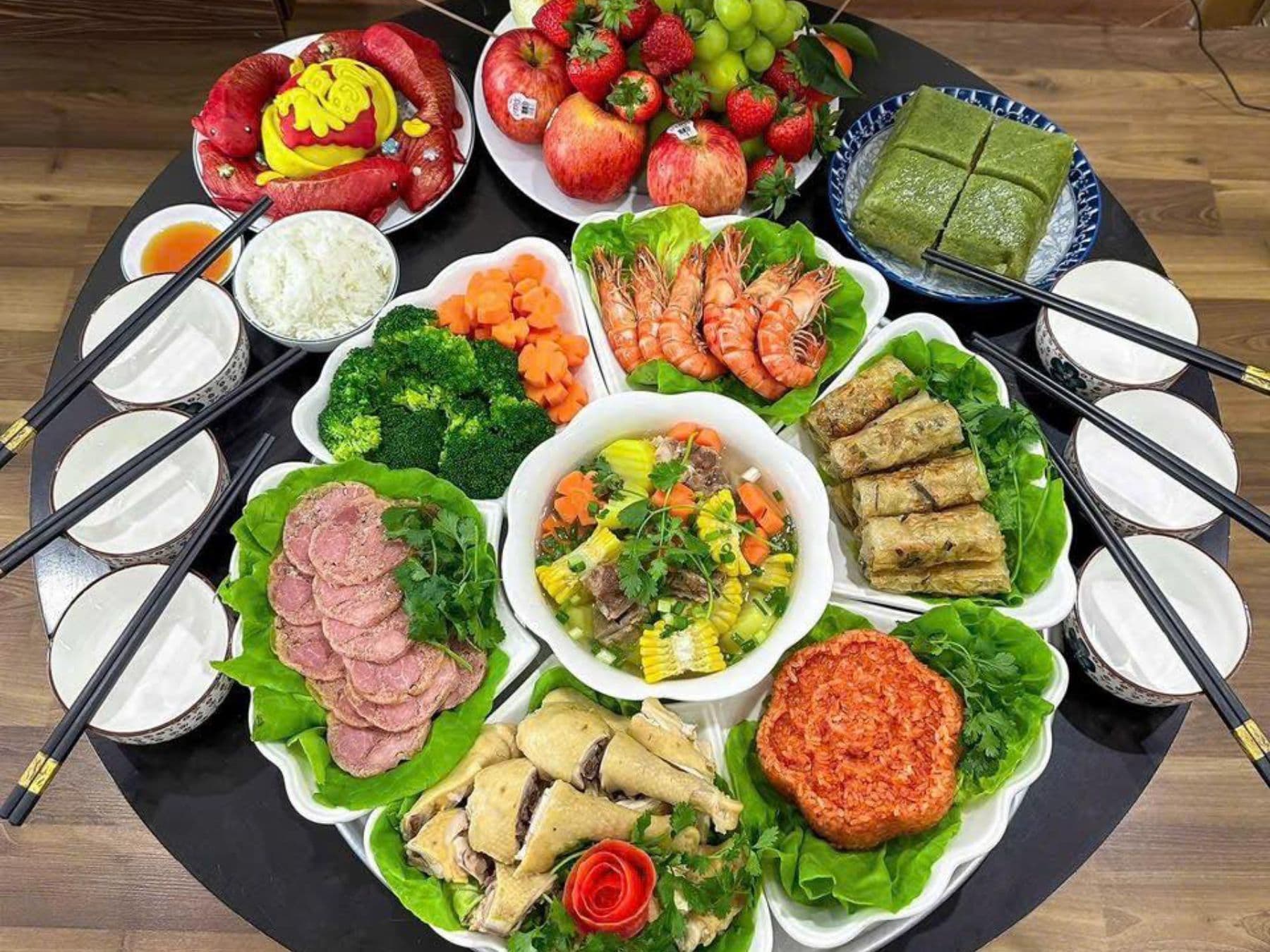 Mâm cỗ cúng Thần Bếp trang trọng với gà luộc, xôi, hoa quả và các món ăn truyền thống, thể hiện lòng thành kính.