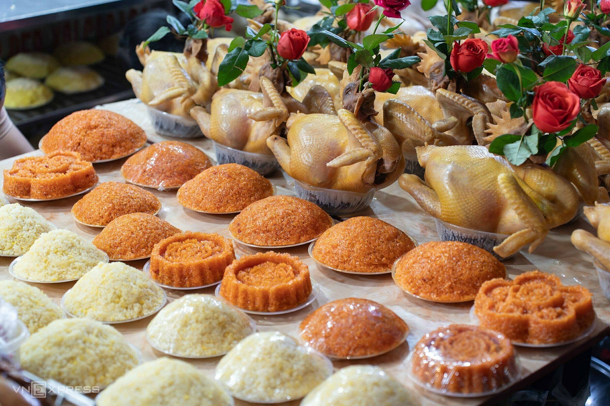 Mâm cỗ cúng Táo Quân với gà luộc, xôi và hoa hồng đỏ, chuẩn bị tiễn ông Công ông Táo về trời.