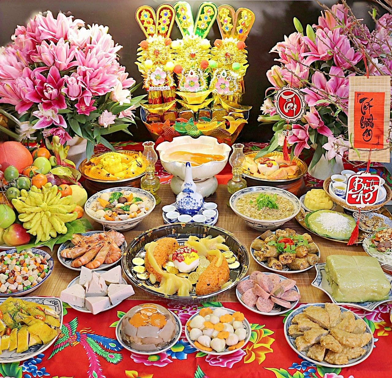 Mâm cúng Ông Công Ông Táo truyền thống với nhiều lễ vật, hoa tươi và tượng Táo Quân