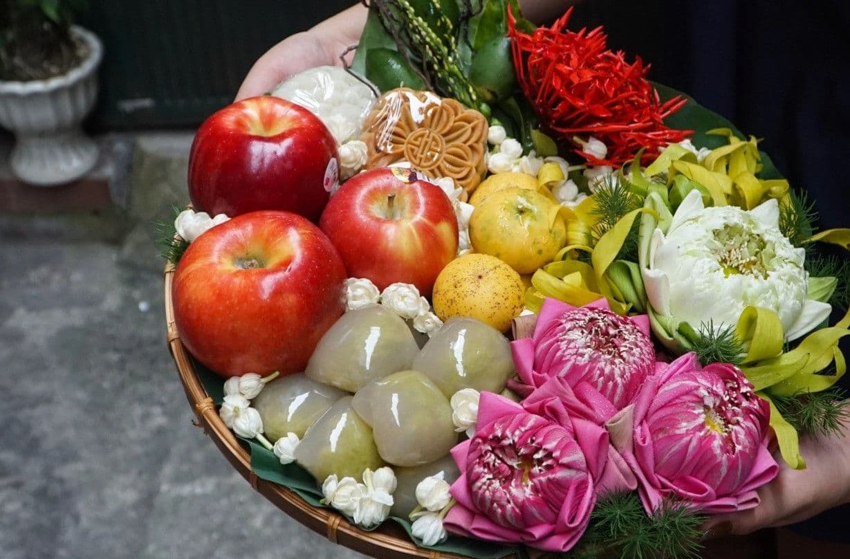Mâm lễ cúng Mùng 1 truyền thống với trái cây, bánh và hoa sen, thể hiện sự chuẩn bị chu đáo cho nghi lễ đầu tháng.