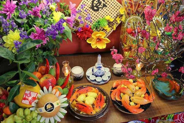 Mâm lễ vật cúng ông Công ông Táo với hoa tươi, quả ngọt và các vật phẩm trang trọng, tượng trưng cho lòng thành kính.