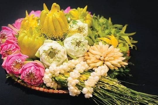 Mâm lễ vật đơn giản với hoa sen, hoa cúc và trái cây, tượng trưng cho lòng thành kính dâng cúng trong ngày Rằm tháng Chạp.
