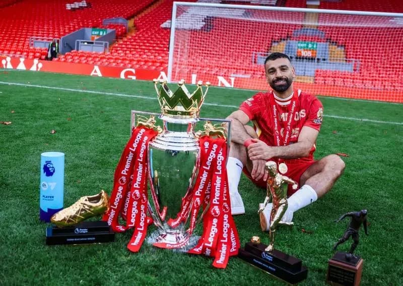 Mohamed Salah ngồi trên sân Anfield cùng chiếc cúp Premier League và các giải thưởng cá nhân, biểu tượng cho chín năm vàng son.
