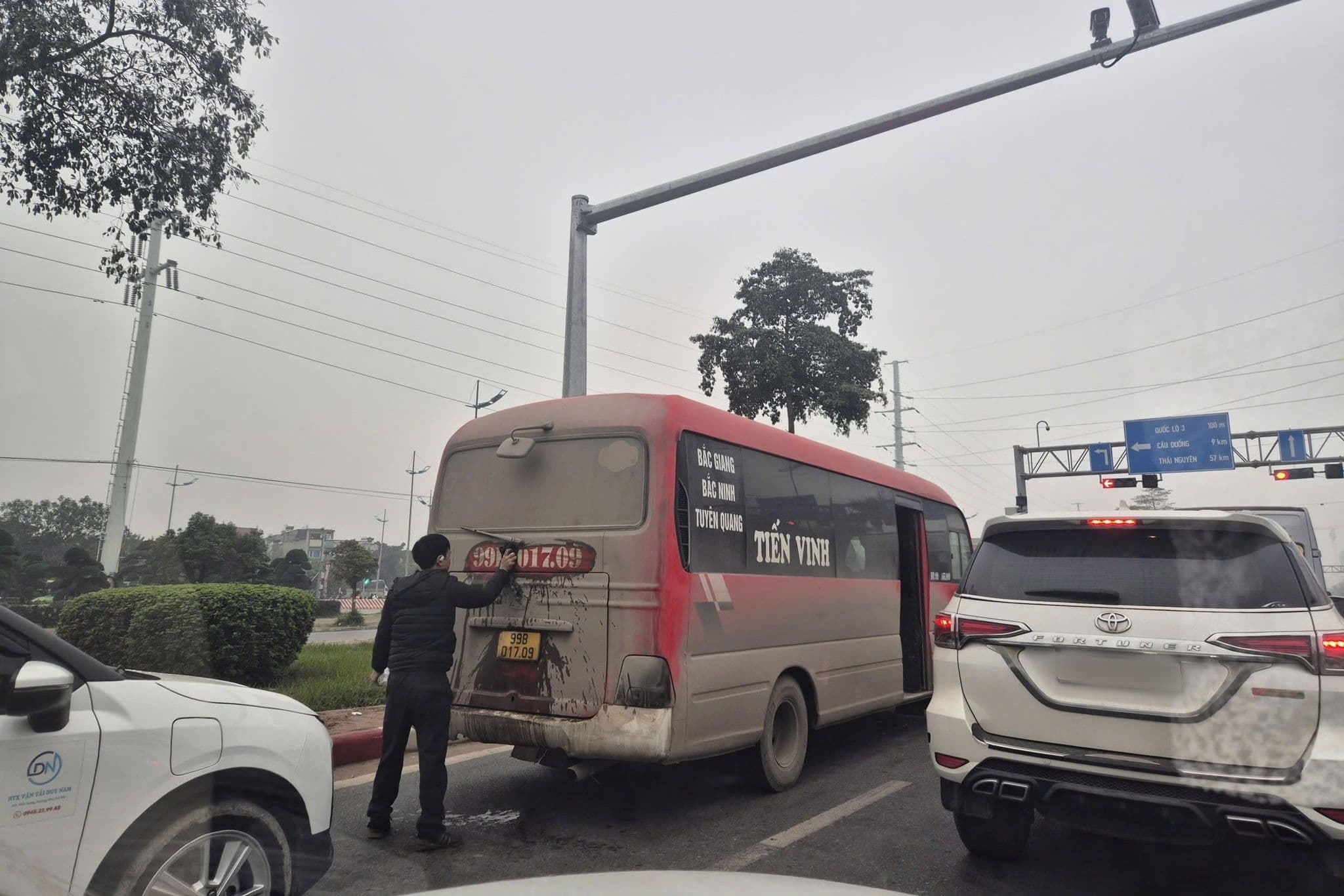 Một chiếc xe buýt với biển số bị che mờ hoặc bẩn, minh họa thách thức từ hành vi đối phó trong văn hóa giao thông.