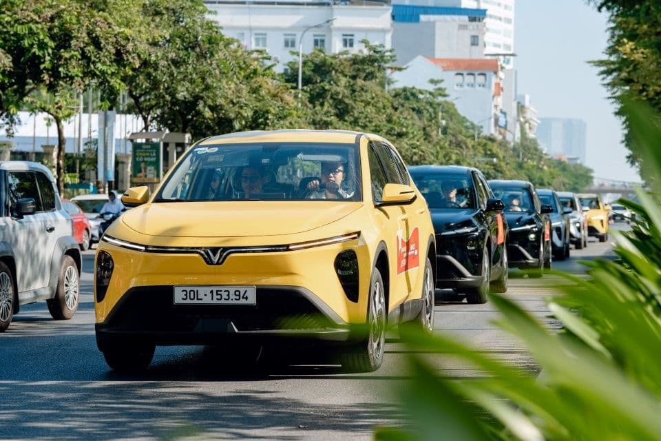 Một chiếc xe điện VinFast màu vàng đang di chuyển trên đường, thể hiện sản phẩm và công nghệ mà hãng tập trung phát triển.
