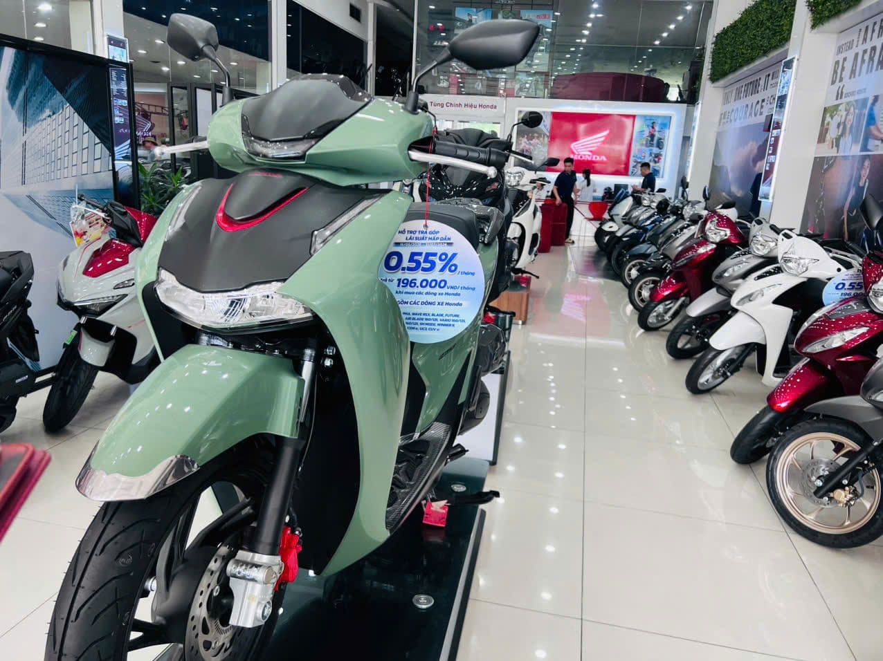 Một chiếc xe tay ga Honda SH màu xanh lá cây đang được trưng bày trong showroom với biển giảm giá, tượng trưng cho vị thế cao cấp và cạnh tranh thị trường.