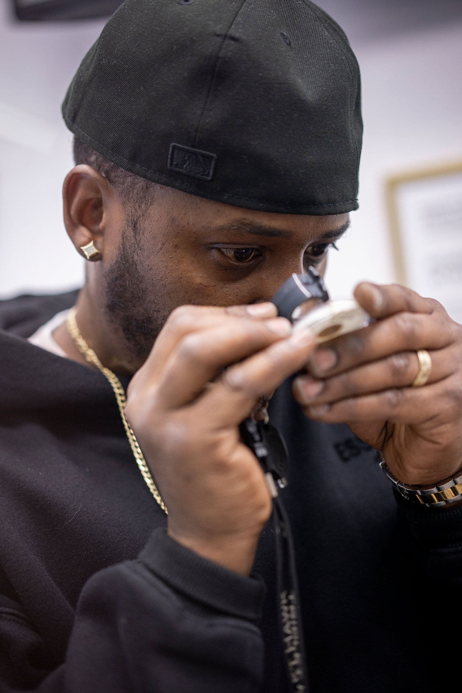 Một chuyên gia kim hoàn đang kiểm tra kỹ lưỡng một món trang sức vàng bằng kính lúp tại một cửa hàng trên phố kim cương.