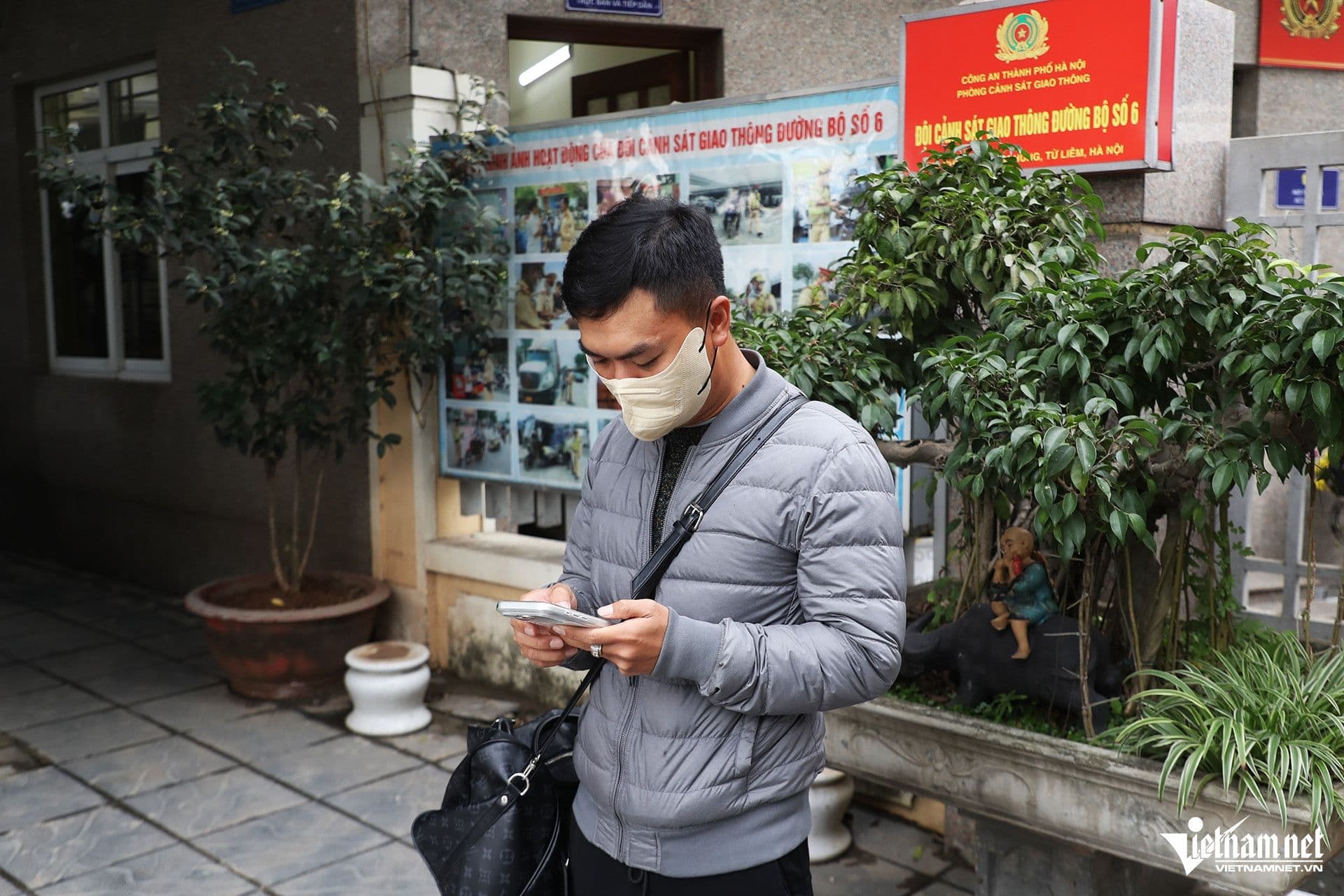 Một cảnh sát giao thông hóa trang thành hành khách, sử dụng điện thoại để nắm bắt tình hình, minh họa chiến thuật 'hóa thân' của CSGT.