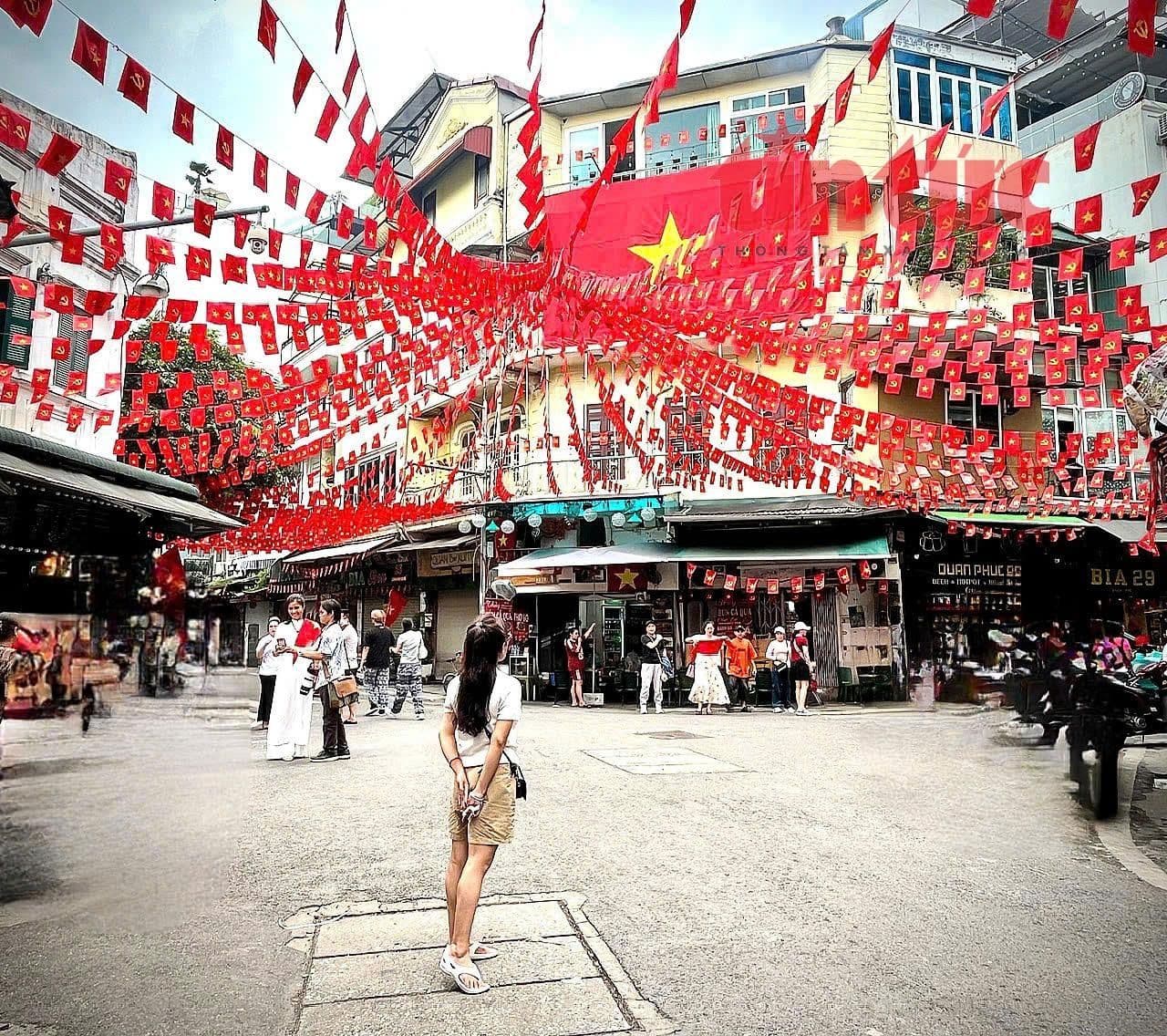 Một con phố ở Hà Nội được trang hoàng rực rỡ với cờ đỏ sao vàng và cờ Đảng chào mừng Quốc khánh 2/9, thể hiện niềm tự hào dân tộc.