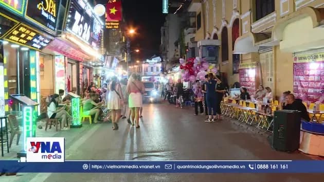 Một con phố nhộn nhịp vào ban đêm ở Hà Nội với các hàng quán kinh doanh trên vỉa hè, liên quan đến đề xuất thí điểm cho thuê vỉa hè.