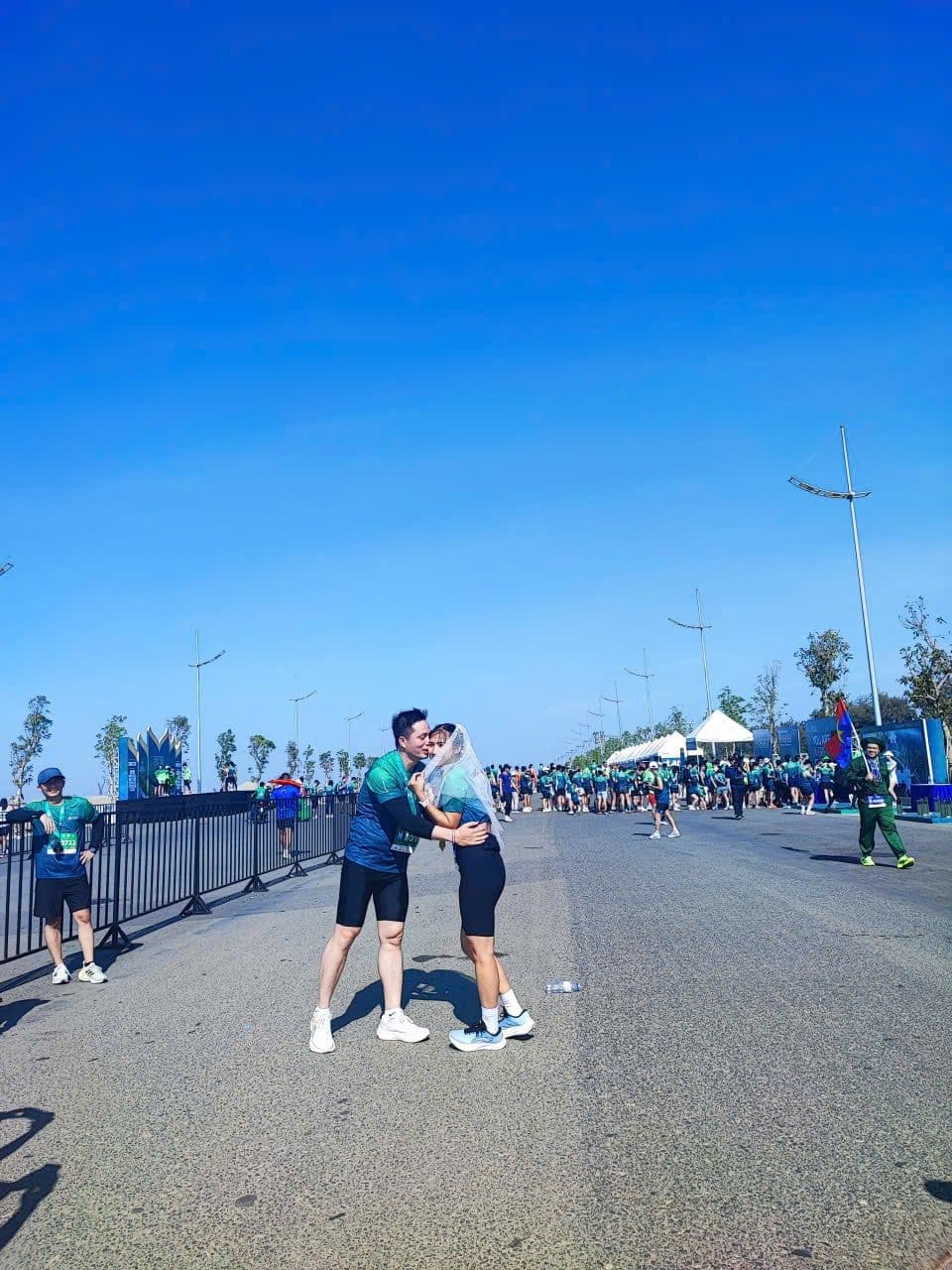 Một cặp đôi ôm nhau trên đường chạy marathon tại Cần Giờ, thể hiện tinh thần cộng đồng gắn kết và lối sống năng động tại Vinhomes Green Paradise.