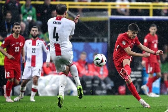 Một cầu thủ bóng đá đang sút bóng trong trận đấu.