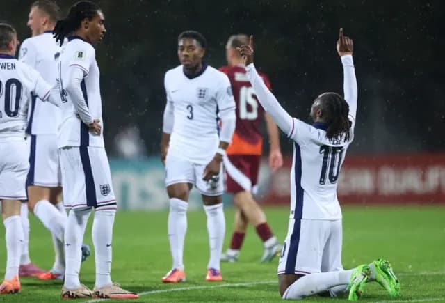 Một cầu thủ bóng đá quỳ gối ăn mừng với hai tay giơ cao, biểu tượng cho giấc mơ World Cup trở thành hiện thực.