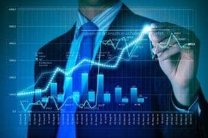 Một doanh nhân tương tác với biểu đồ tài chính, tượng trưng cho tầm nhìn chiến lược và kinh nghiệm đầu tư của các tỷ phú.