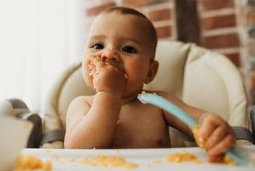 Một em bé đang ăn, tượng trưng cho tương lai và hy vọng phục hồi tuổi thọ ở California.