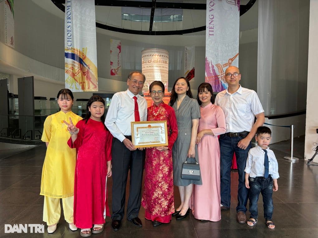 Một gia đình Việt Nam nhiều thế hệ mặc áo dài truyền thống nhận bằng khen Gia đình văn hóa tiêu biểu.