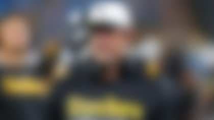 Một huấn luyện viên hoặc quản lý NFL đang suy tư, tượng trưng cho những quyết định chiến lược và canh bạc sau hậu trường trong xây dựng đội hình.