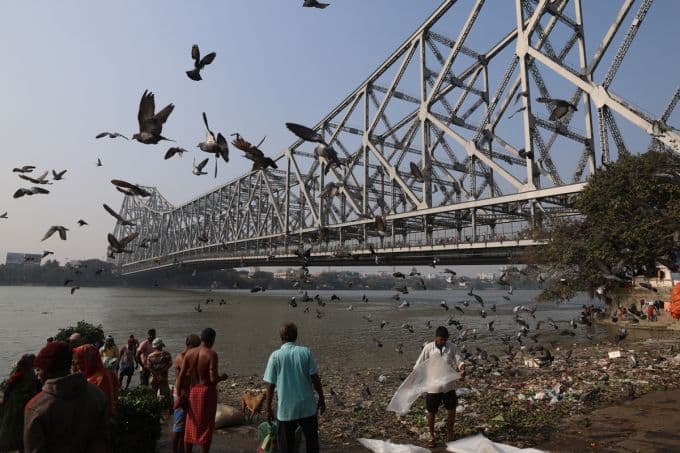 Một khung cảnh đông đúc bên bờ sông ở Tây Bengal, Ấn Độ, nơi virus Nipah đã bùng phát, tượng trưng cho nguy cơ dịch bệnh toàn cầu mà Việt Nam cần phòng ngừa.