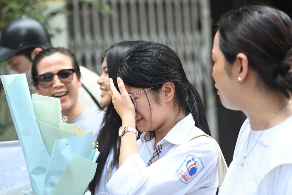 Một nữ sinh bật khóc, che mặt sau khi hoàn thành bài thi môn Toán, thể hiện sự căng thẳng và áp lực của kỳ thi.