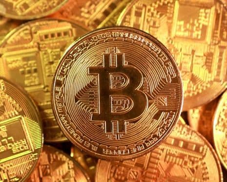 Một đồng tiền Bitcoin vàng nổi bật trên nền các đồng tiền mã hóa khác, tượng trưng cho sự biến động của thị trường.
