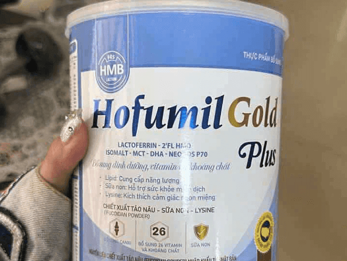 Một người đang cầm hộp sữa Hofumil Gold Plus, tượng trưng cho vấn đề thực phẩm không rõ nguồn gốc hoặc kém chất lượng mà Nghị định 46/2026 nhằm giải quyết.