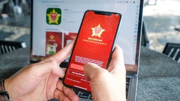 Một người đang cầm điện thoại thông minh hiển thị ứng dụng, thể hiện sự phổ biến của tin tức tức thời và tương tác số.
