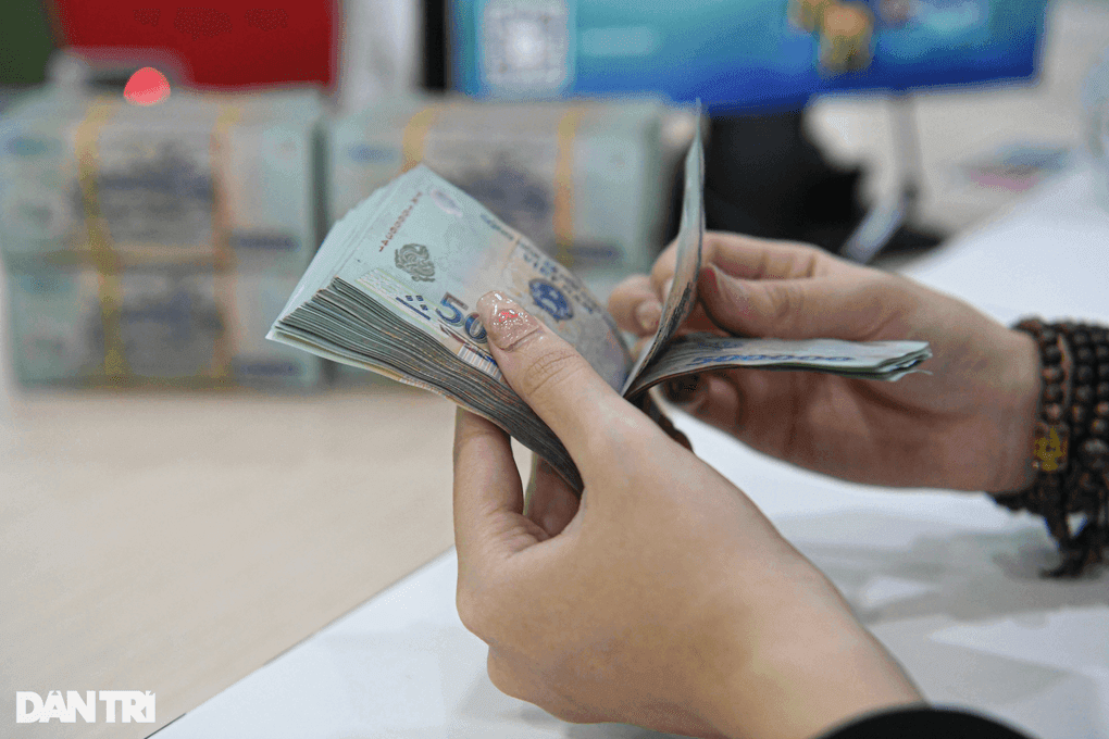 Một người đang đếm tiền mặt, thể hiện phương thức chi trả lương truyền thống mà doanh nghiệp đang chuyển đổi.