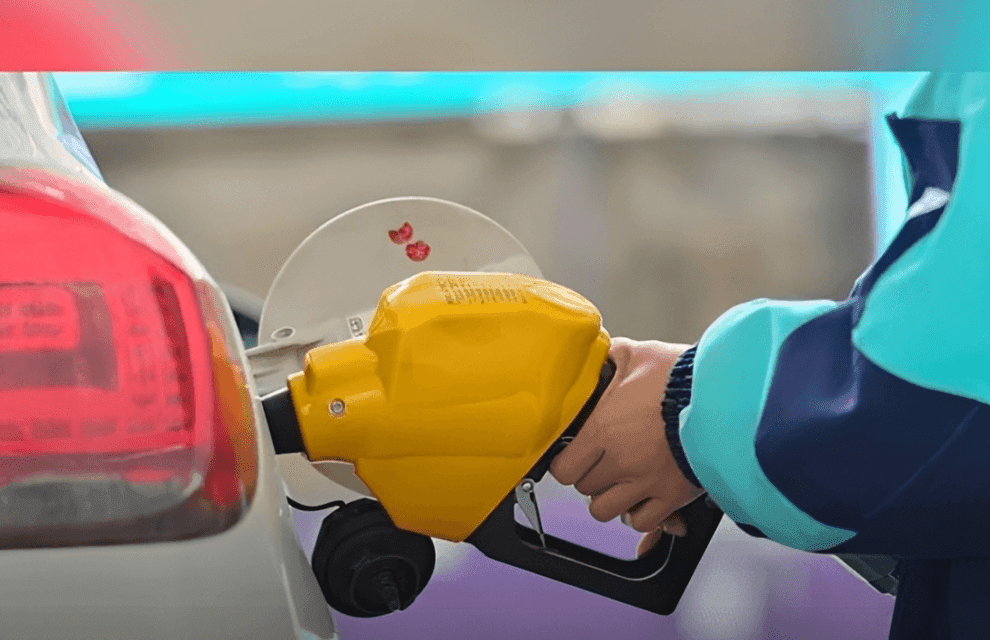 Một người đang đổ xăng vào ô tô, minh họa sự tương tác trực tiếp của người dân với giá xăng dầu biến động.