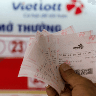 Một người cầm trên tay những tấm vé số Vietlott, biểu tượng của hy vọng và ước mơ đổi đời.