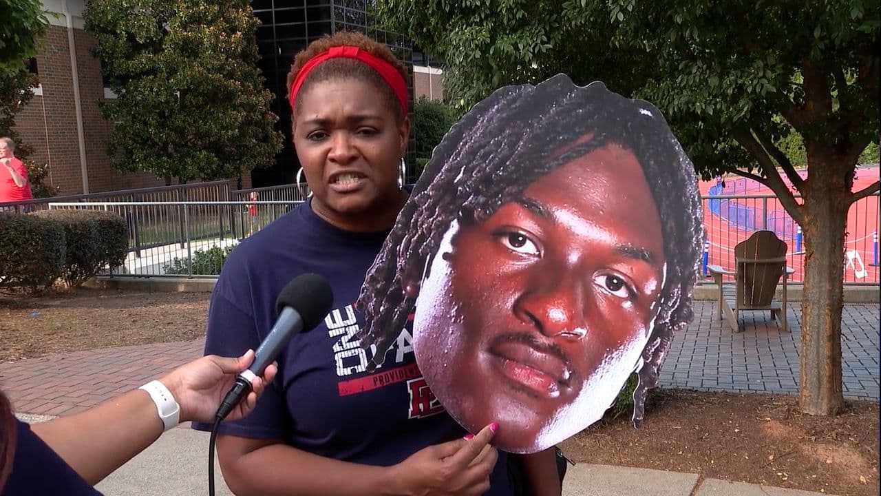 Một người mẹ đang phát biểu, tượng trưng cho tiếng nói của phụ huynh và nạn nhân trong cuộc chiến chống lại sự bóc lột trên Roblox.