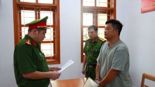 Một người đàn ông bị cảnh sát bắt giữ, tượng trưng cho việc NSƯT Kiều Thanh bị khởi tố và tạm giam.