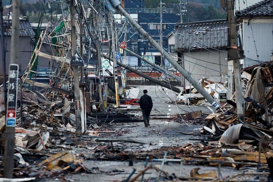 Một người đàn ông đi qua con phố hoang tàn sau động đất ở Nhật Bản